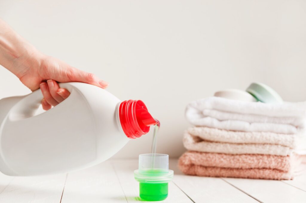 Close up of female hands pouring liquid laundry detergent