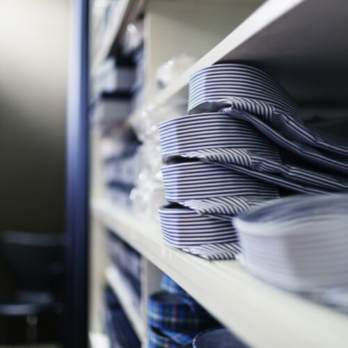 Shirts stacked in shelves at clothing store